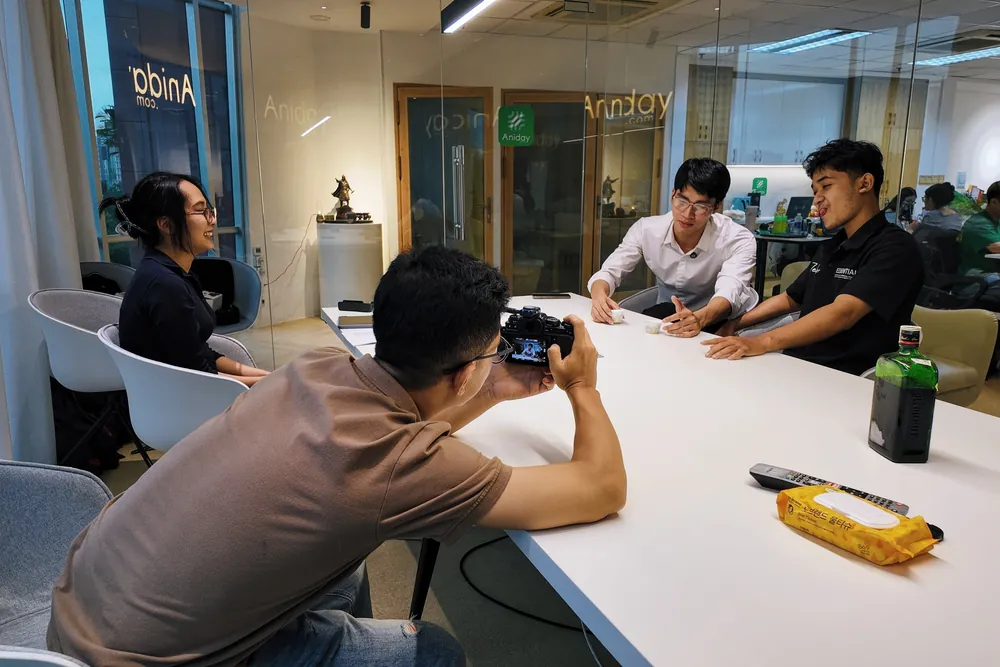 Kha directing actors at a table