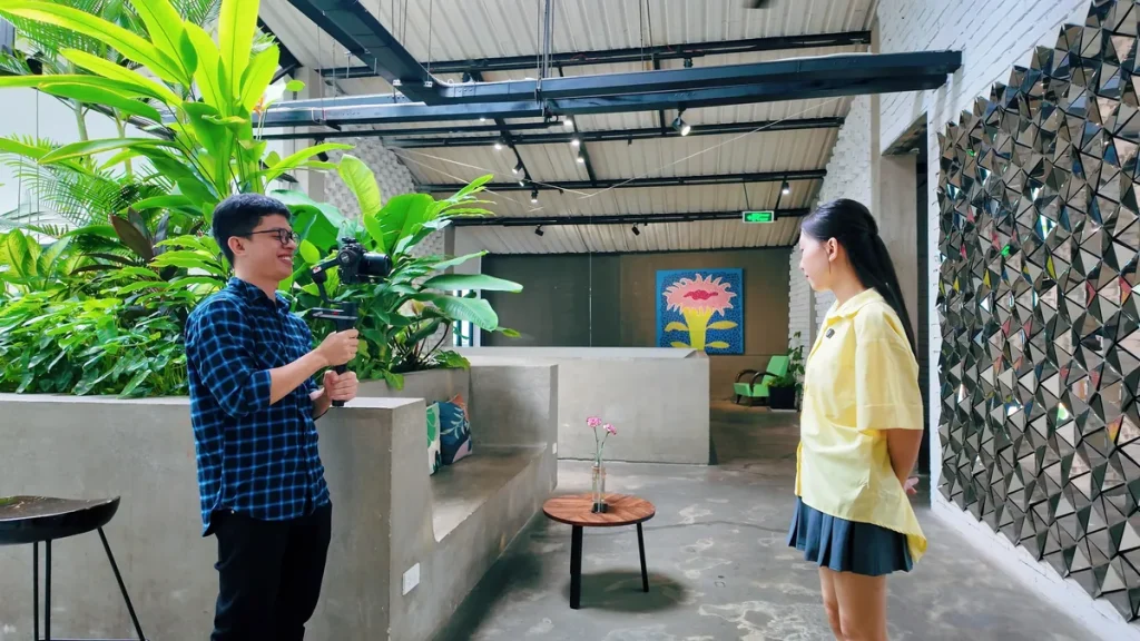 Kha interviewing a guest in a garden office
