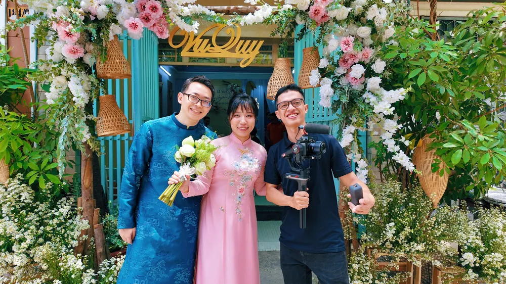Kha with a gimbal next to the bride and groom